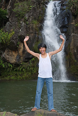 Image showing Boy cheering at waterfall