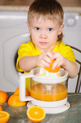 Image showing The child to wring out juice