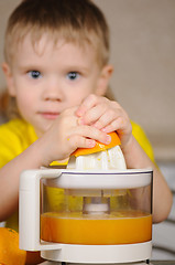 Image showing The child to wring out juice