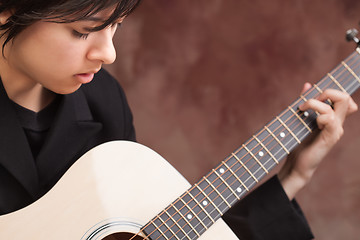 Image showing Attractive Ethnic Girl Plays Guitar