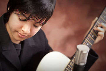 Image showing Attractive Ethnic Girl Plays Guitar