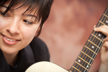 Image showing Attractive Ethnic Girl Plays Guitar