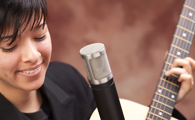 Image showing Attractive Ethnic Girl Plays Guitar