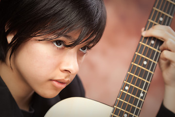 Image showing Attractive Ethnic Girl Plays Guitar