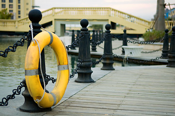 Image showing Yellow life buoy on fence