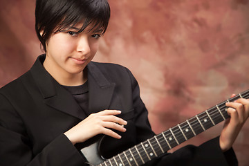 Image showing Multiethnic Girl Poses with Electric Guitar