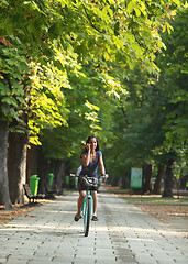 Image showing Woman on the phone riding bicycle