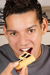 Image showing Young man eating fruit tart