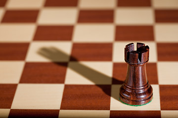 Image showing Chess piece - a black rook on a chessboard.