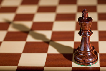 Image showing Chess piece - a black king on a chessboard.