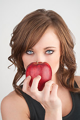 Image showing Beautiful girl holding an apple in front of her face