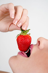 Image showing Closeup of girl biting a strawberry