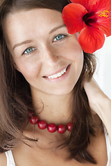 Image showing smiling brunette with red flower