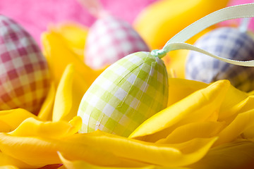 Image showing Easter eggs on yellow tulip petals