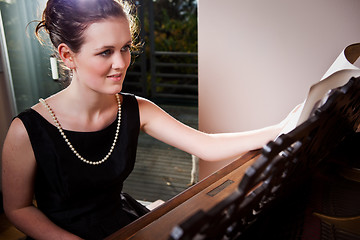 Image showing Beautiful teenager playing piano