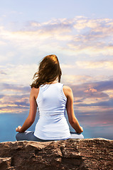 Image showing Young girl meditating at sunset