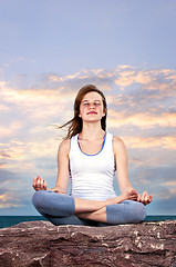 Image showing Young girl meditating at sunset