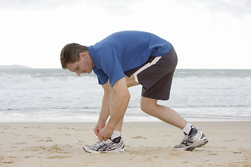 Image showing Runner tying his shoes