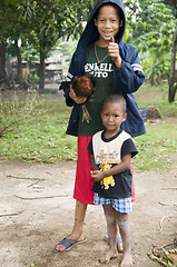 Image showing editorial happy boy with pet hen chicken corn island nicaragua