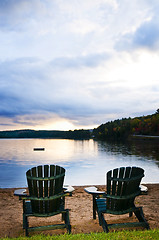 Image showing Wooden chairs at sunset on beach