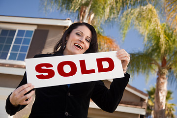 Image showing Attractive Hispanic Woman Holding Sold Sign In Front of House