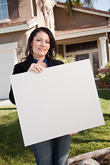 Image showing Attractive Hispanic Woman Holding Blank Sign in Front of House