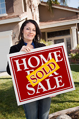 Image showing Hispanic Woman Holding Red Sold Real Estate Sign In Front of Hou