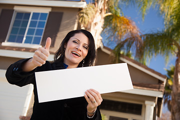 Image showing Attractive Hispanic Woman Holding Blank Sign in Front of House