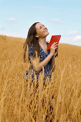 Image showing woman with a book in cereals field 