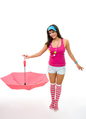 Image showing Young woman in pink stand and holding color umberella