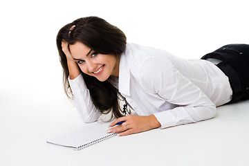 Image showing Woman laying on the floor with note book smiling and laughing