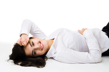 Image showing Happy young woman in white clothes lay on the floor