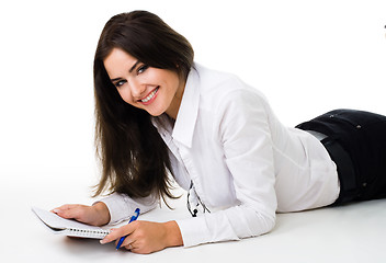 Image showing woman writ in notepad laying on the floor