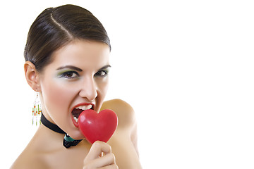 Image showing attractive woman biting a red heart