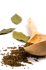 Image showing cumin on wooden spoon and bay leaves