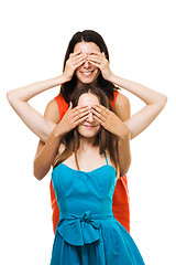 Image showing Two womans play with their hands in color dresses