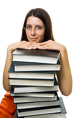 Image showing Clever woman student on pile of books