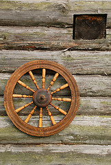 Image showing Hand Spinning Wheel On The Log House Wall