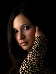 Image showing Young brunette on black touching hair