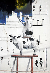 Image showing Painting of two cows painting a wall