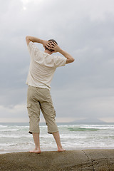 Image showing Man relaxing on a rock at the sea