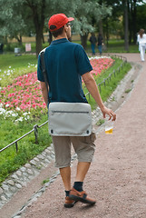 Image showing young man walking with a beer