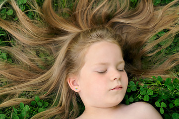 Image showing Little girl laying on the grass