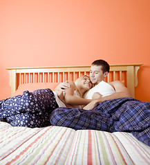 Image showing Young Couple in Pajamas Sitting on Bed