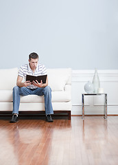 Image showing Man Reading on Living Room Couch