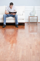 Image showing Young Man Sitting on Sofa Reading