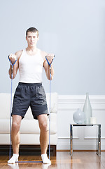 Image showing Man Using Resistance Bands in Living Room