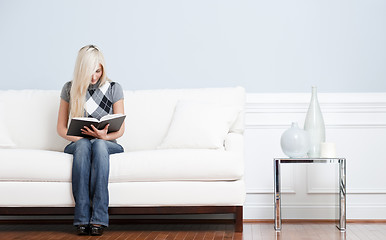 Image showing Woman Sitting on Couch and Reading Book