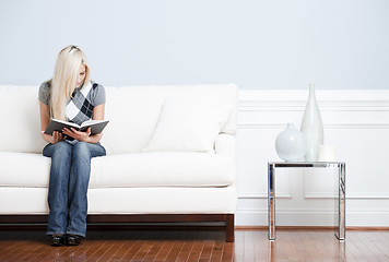 Image showing Young Woman Sitting on Sofa Reading