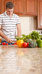 Image showing Young Man Cutting Tomato